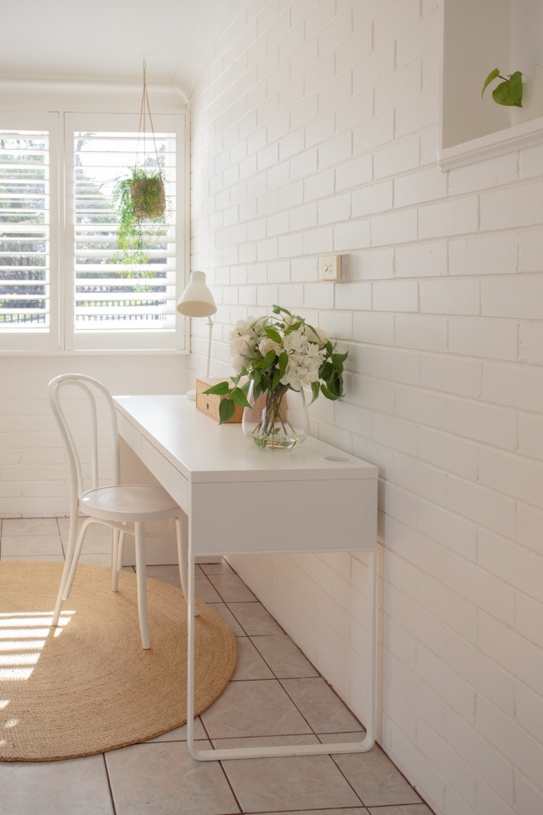 white home office idea with desk against brick wall