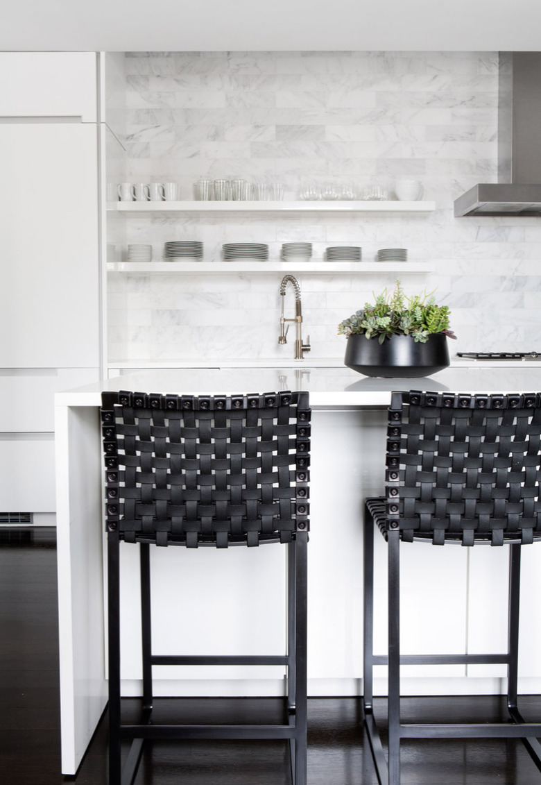 white kitchens with wood floors, black bar stools, and stainless steel hood