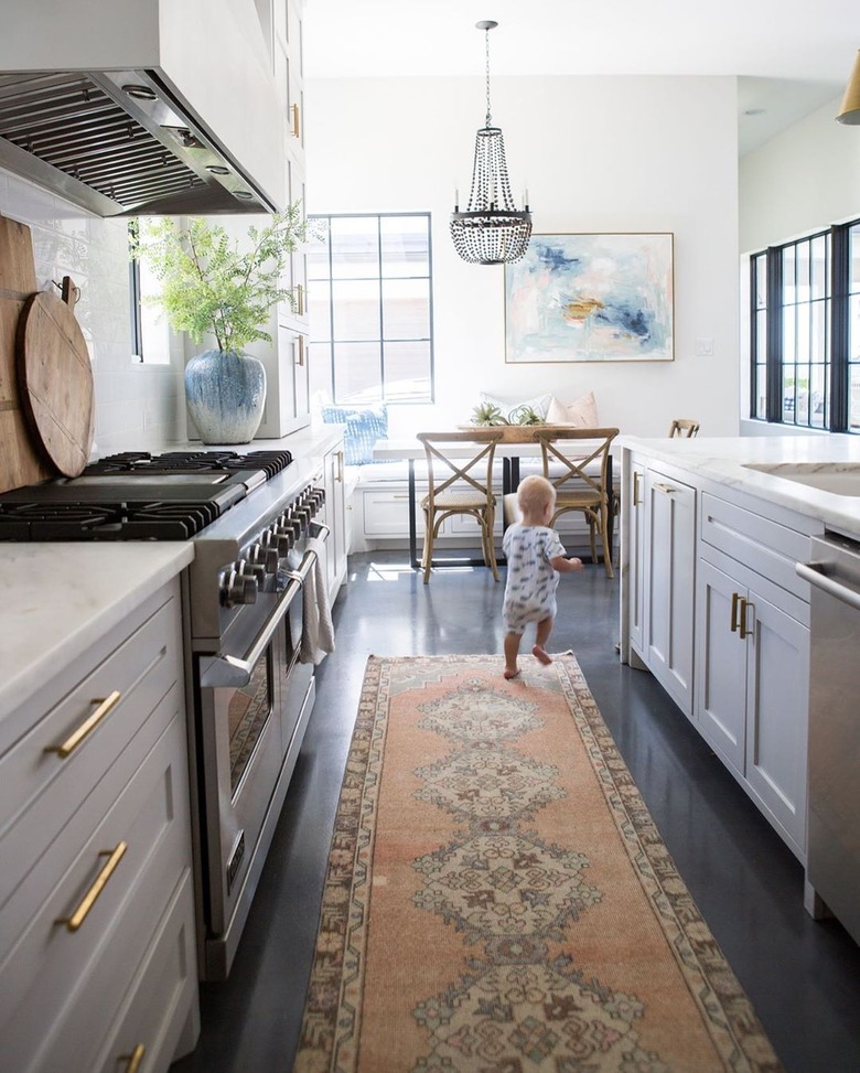 white kitchen dark floors with brass hardware and dark concrete floors with kitchen runner