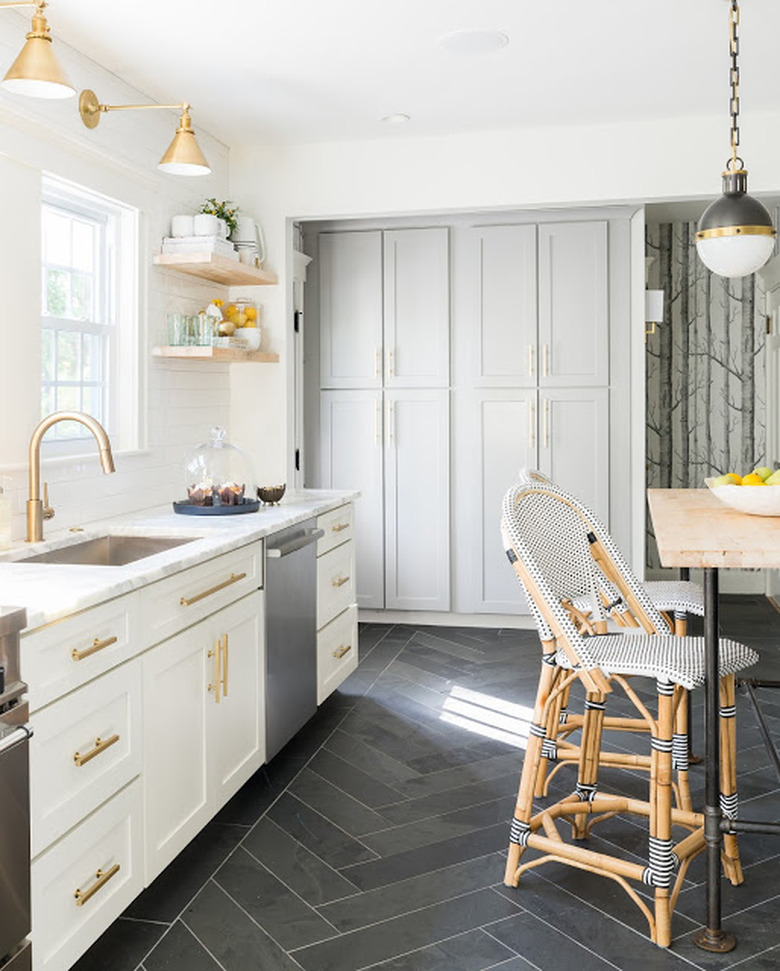 white kitchen dark floors with white cabinets and brass hardware