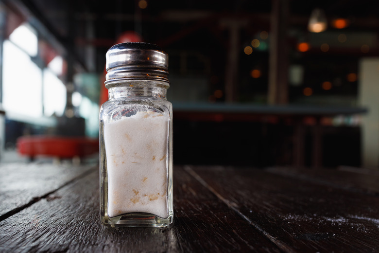 Glass salt shaker on a wooden table