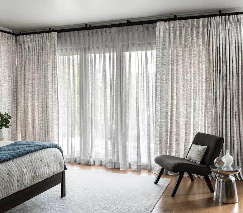 window treatments for sliding glass doors in minimal bedroom with rug and gray side chair