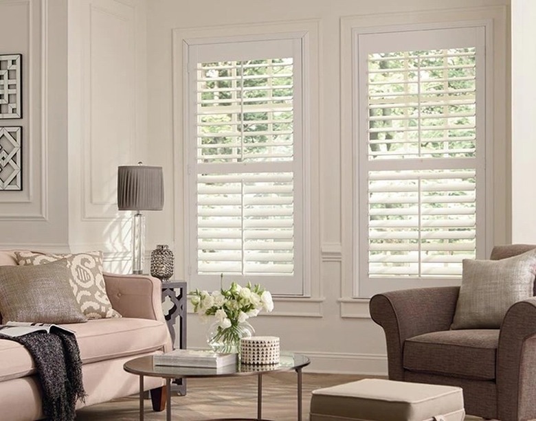 A living room with white louvered interior shutters