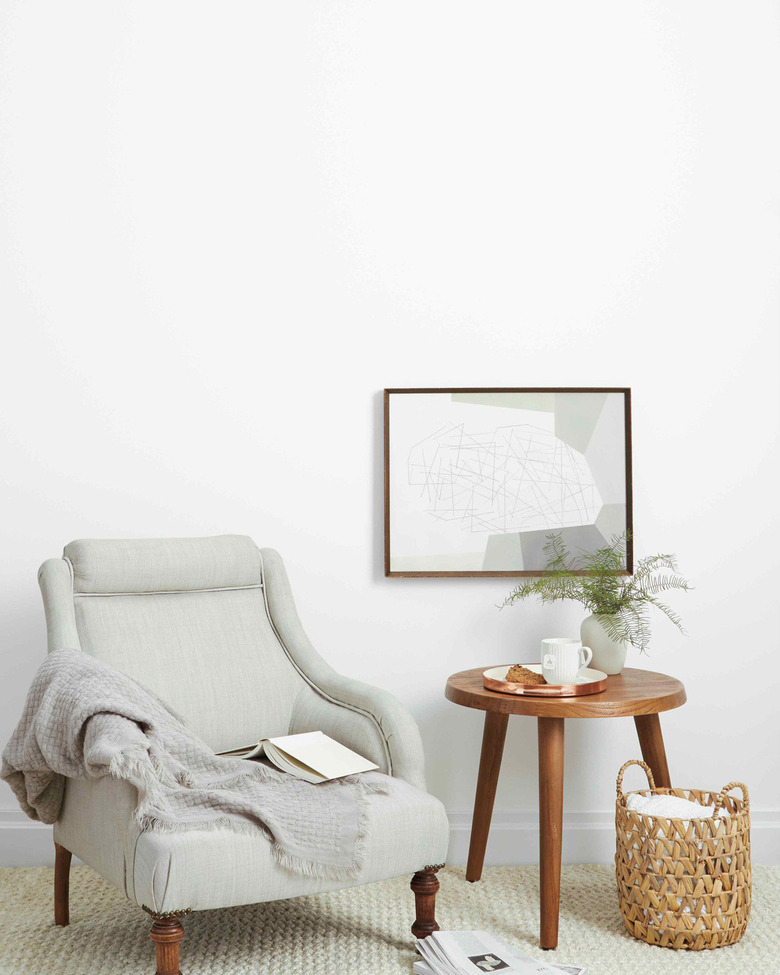 room with gray chair and wood side table