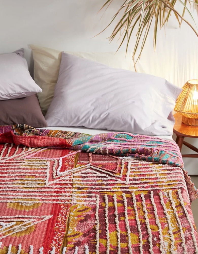 Bed with boho style quilt, pillows.