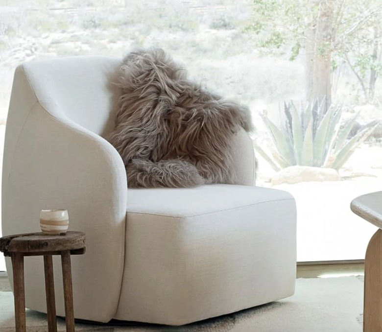 Off white accent chair with sheepskin throw.