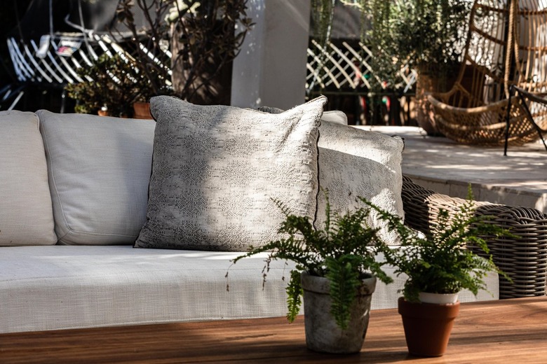 A white sofa at a wood table with plants