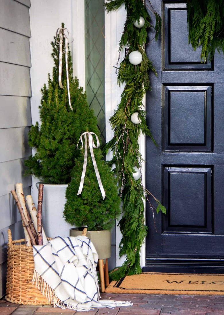 winter front porch with ribbons on evergreens