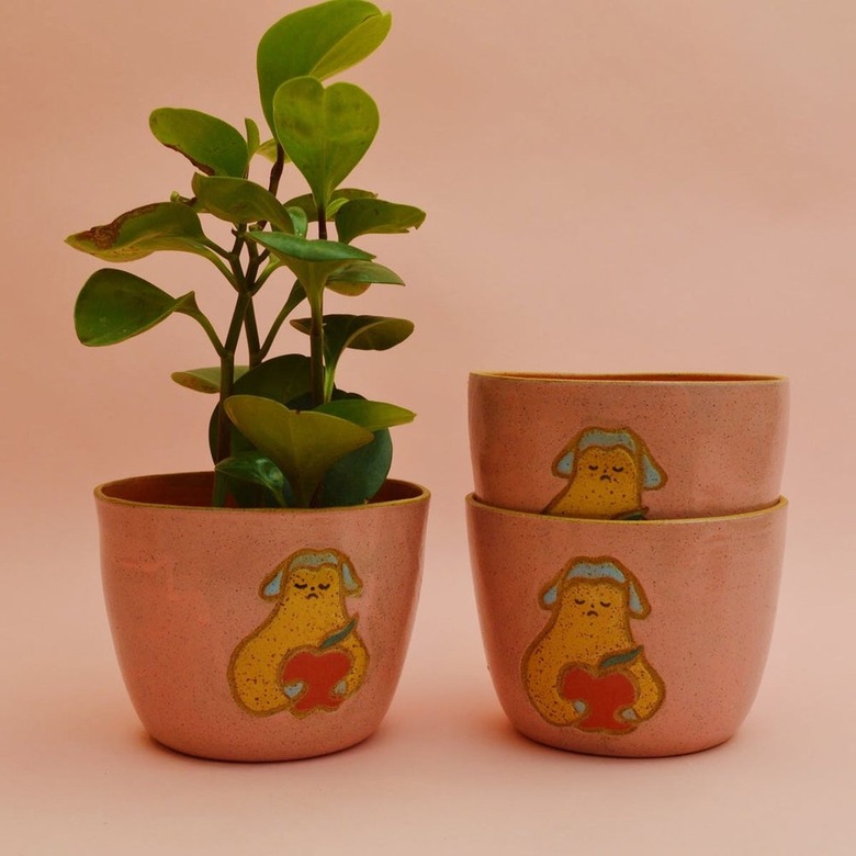 This planter is thrown on the wheel with a speckled clay body. It was then carved and painted. Coral glaze on the interior. Pink glaze on the exterior.