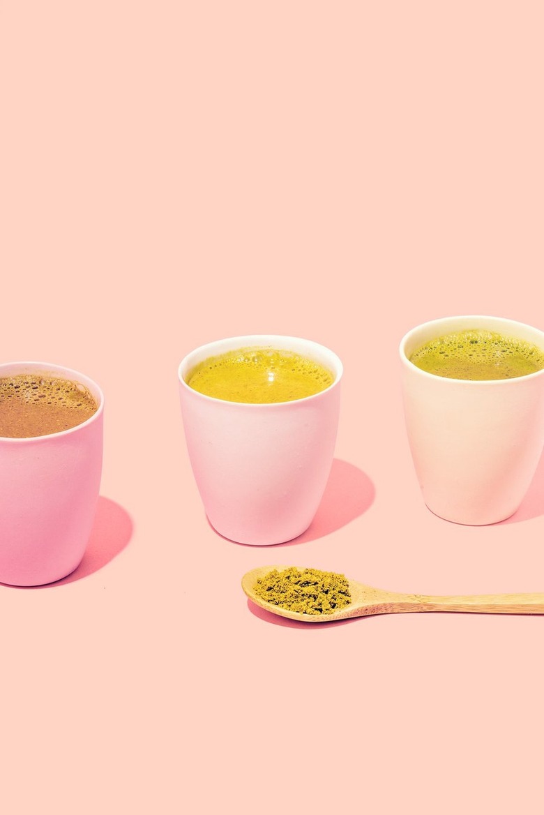 three cups with tea and a spoon with matcha powder