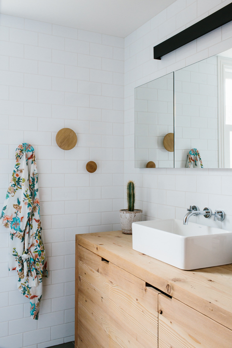 wood vanity cabinet with vessel sink and white subway tile