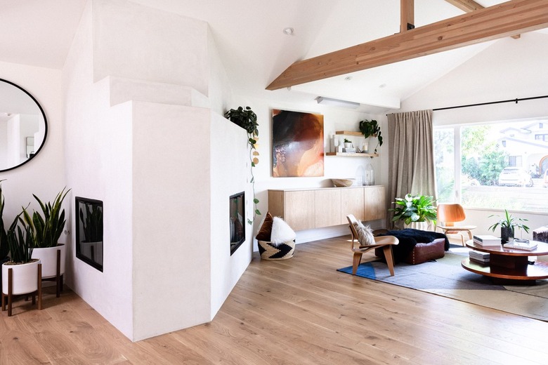 wood beam in modern white room with floating wood credenza and modern fireplace