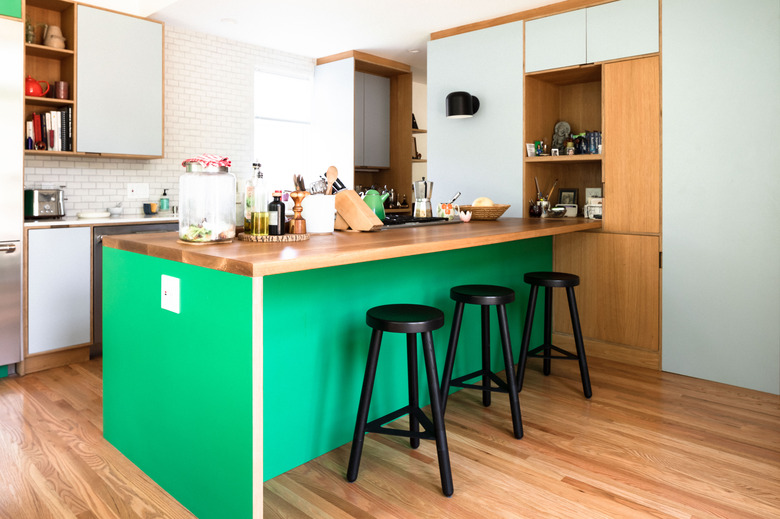 Green kitchen island with hardwood flooring