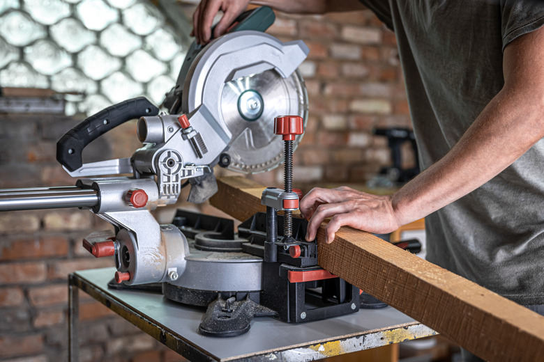 Professional carpenter working with a miter saw.