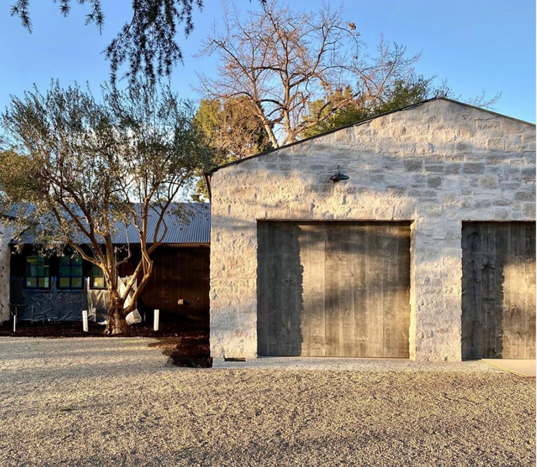 reclaimed wooden garage doors with stone home exterior