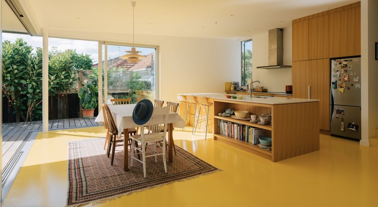 Bold kitchen with light wood cabinets and yellow floors.