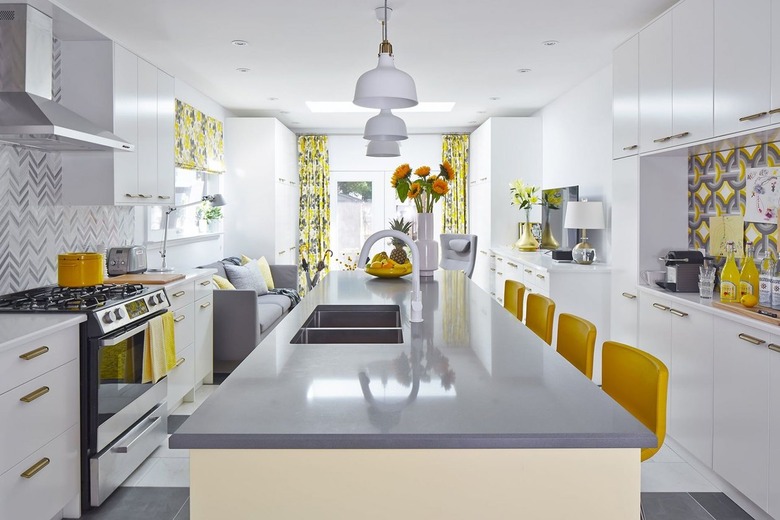 Grey and yellow kitchen with pendant lights and patterned backsplash.