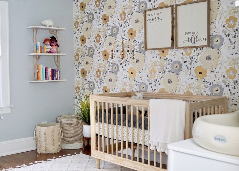 yellow nursery idea with floral accent wall and bluish-gray walls