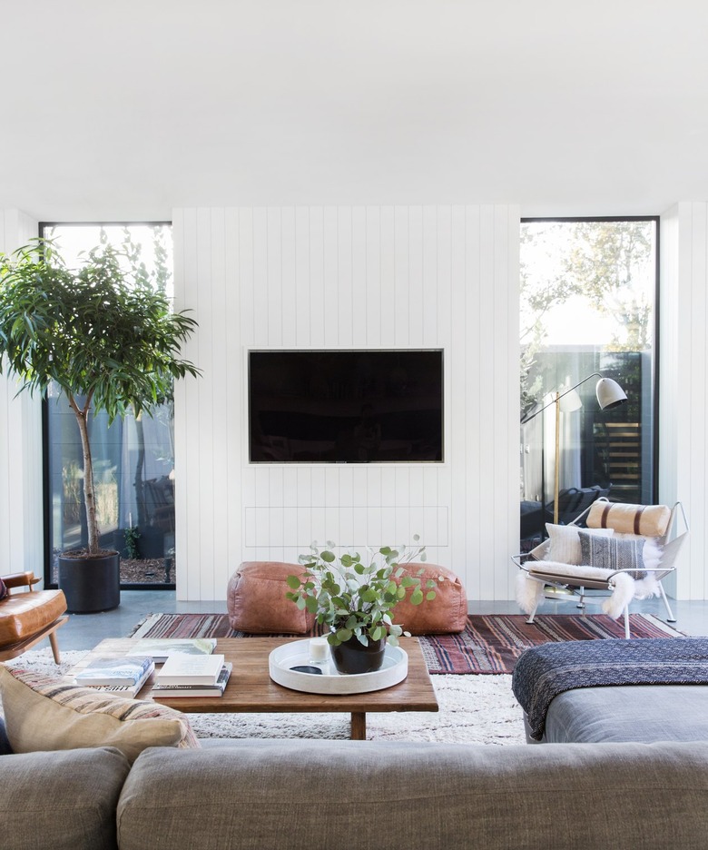 living room TV idea with a tile surround flanked by windows