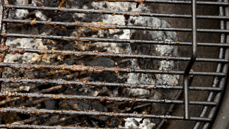 Close up of dirty grill grates with stuck on food particles