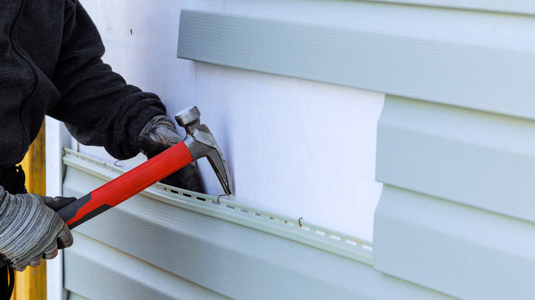 construction worker repairing siding