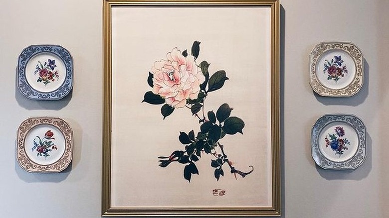 rose painting surrounded by small floral plates