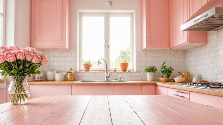 kitchen with pink light cabinets, wood countertops, white subway tile backsplash, stainless steel accents, and fresh greenery and flowers