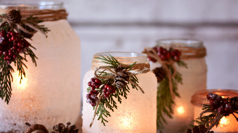 Lighted frosted glass jars with twine, berries, greenery and pinecone