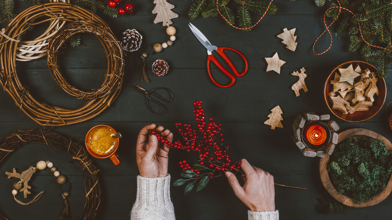 A woman's hands with materials for DIY Christmas decorations