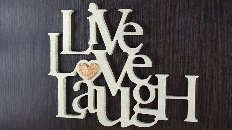 white live laugh love art sign on a dark wood background