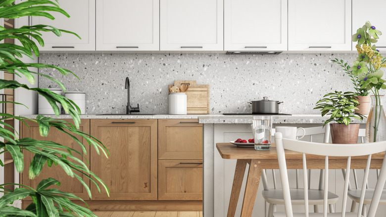 kitchen with light wood shaker lower cabinets, white shaker upper cabinets, and gray terrazzo countertop and splash