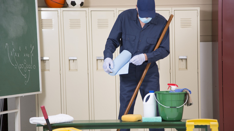 Janitor cleaning with blue paper towels