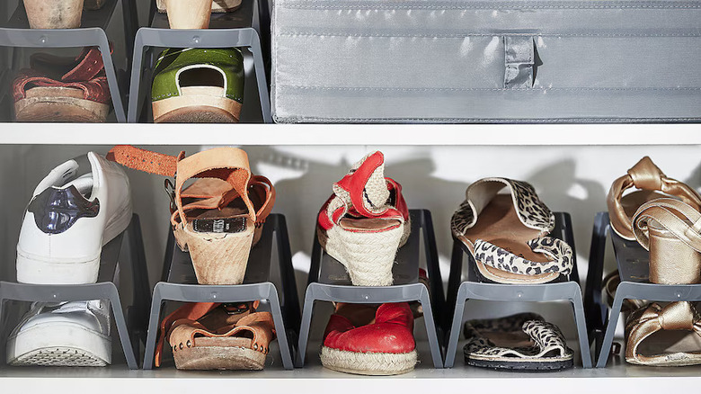 shoes stacked on IKEA MURVEL gray plastic organizers on white closet shelves