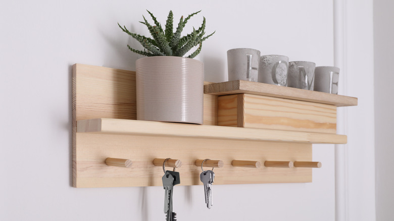 entryway shelf with keys, plant, and candles