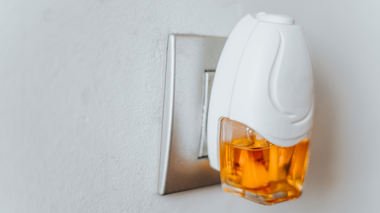 close up of plug-in air freshener with orange liquid