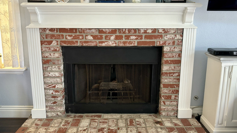 close up of fireplace with DIY brick hearth and white mantel