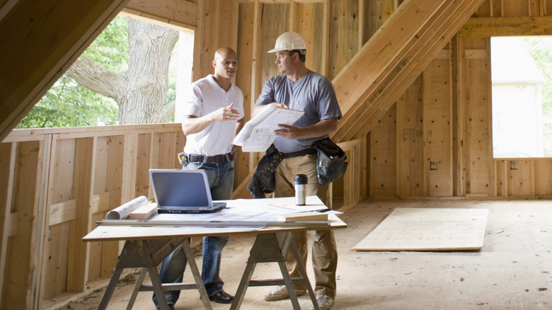 Man and construction worker discussing a document