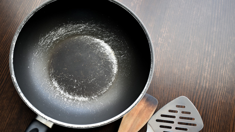 heavily scratched non-stick pan and metal spatula