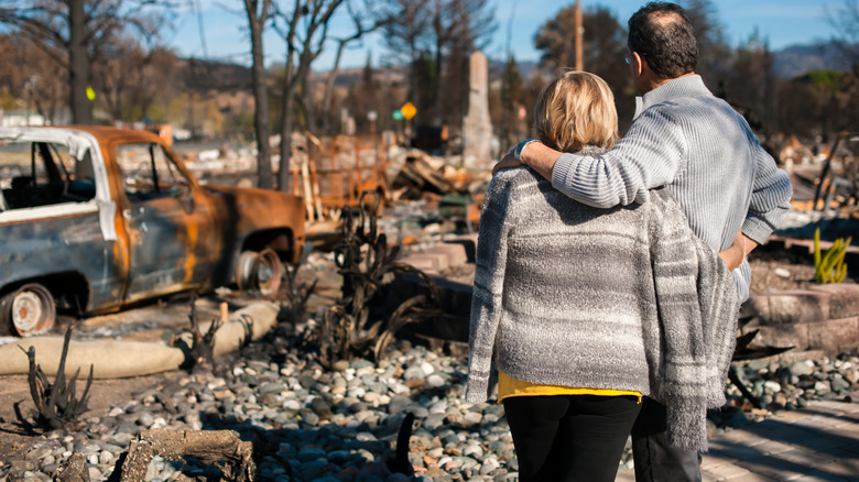 man and woman assessing fire damaged home