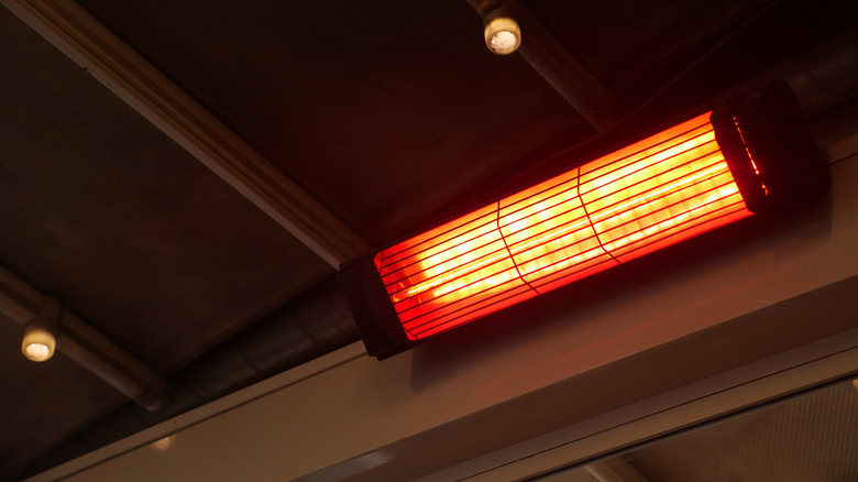 the glow of an infrared heater blaring down from the ceiling of the garage