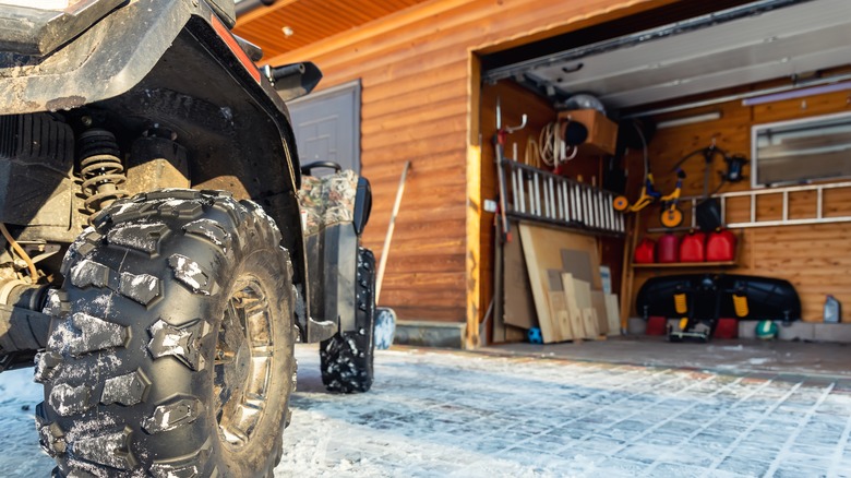 garage in winter with door open and ATV