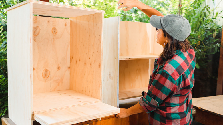 woman with cabinet under construction