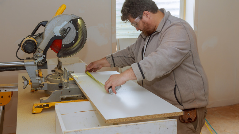 man cutting melamine panel