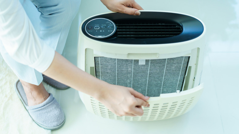 a person changing out an air purifier filter