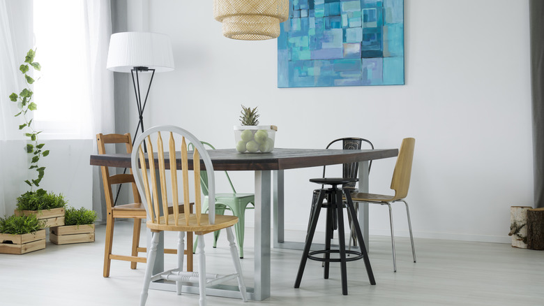 wood pallet dining table with mismatch chairs and lighting