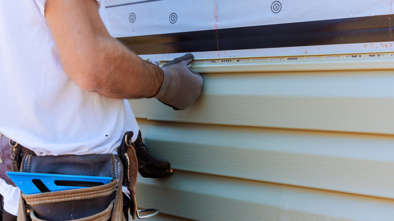 Man installing vinyl siding