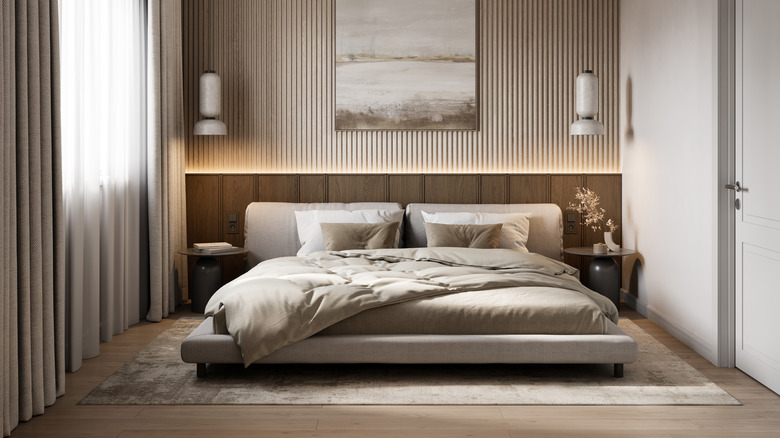 bedroom with taupe comforter, rug, and wood slat accent wall