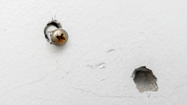 Screwhead and holes in wall