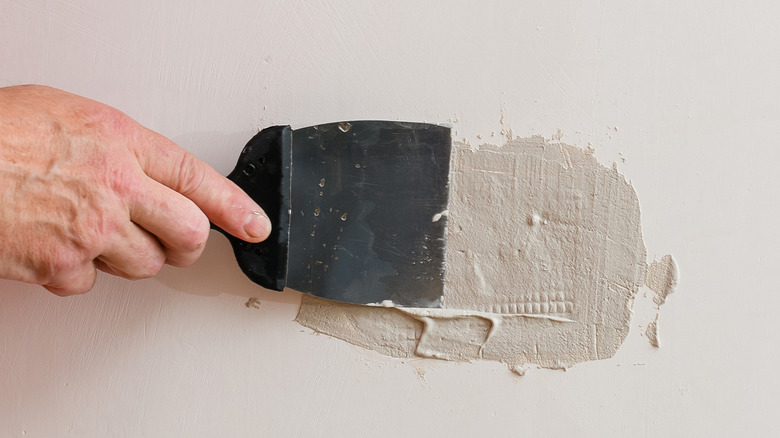 putty knife applying spackle paste