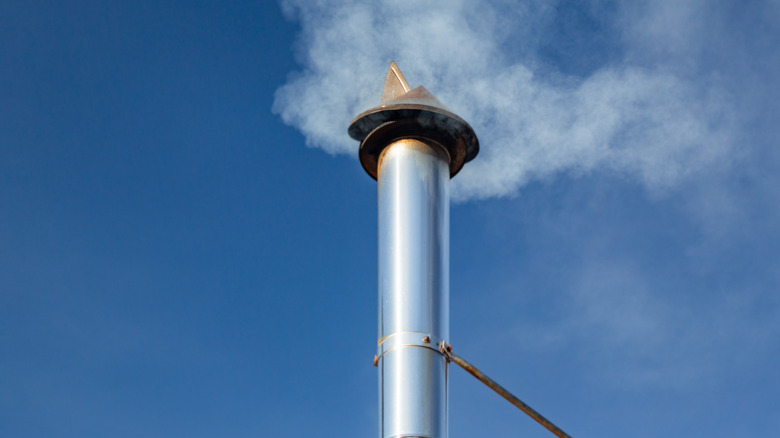 Galvanized chimney pipe above the roofline